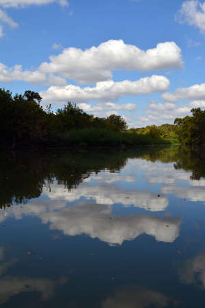 Cloudy Reflection on the San Garbiel River in Texasの写真素材