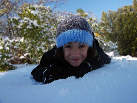 Close up of child ducking out of winter sun in the snowの写真素材