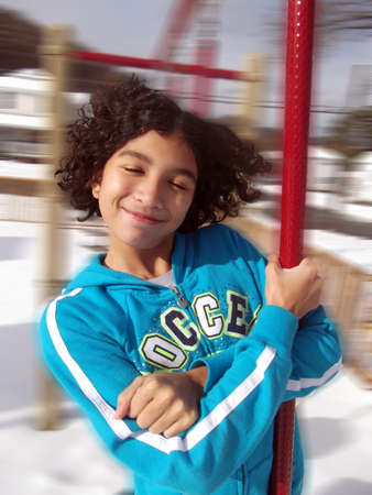 Child spinning on a pole in the parkの写真素材