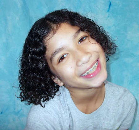 Child with curly hair with her head cocked sideways