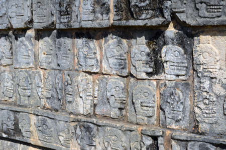 Mayan Skull carvings on a wall at Chichen Itzaの写真素材