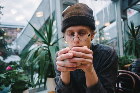 Handsome man in a coffee shop, relaxing, vintage retro lookの写真素材