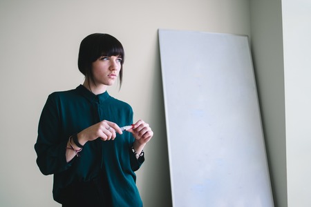 Young handsome worker with marker writing stands at the whiteboard.の写真素材