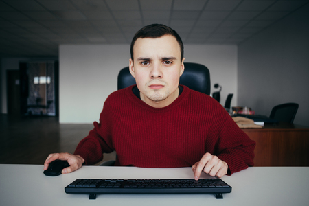 Young hipster office worker sitting at workplace and use computers.の写真素材