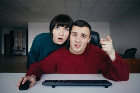 Surprised beautiful people emotionally office workers perceived it that you saw on the computer screen at the background of officeの写真素材