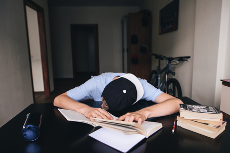 The student fell asleep doing homework at books and notebooks in his room. Teaching at homeの写真素材