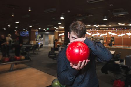 A man in a black shirt holds a bowl for his face and looks and looks for himの写真素材