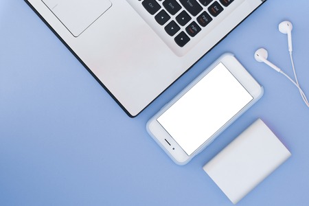 Laptop, phone and pencil on a blue background. Flat Lay composition and place for text. Top view.の写真素材