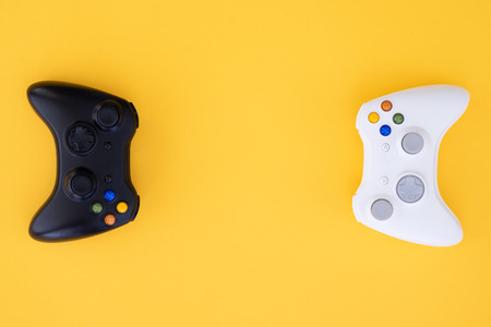 Black and white joystick on a yellow background. White and black gamepad is isolated on a yellow...