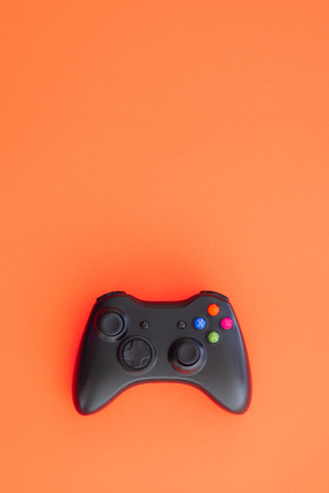 Black joystick is isolated on a red background. Computer game competition. Gaming concept. Copyspace