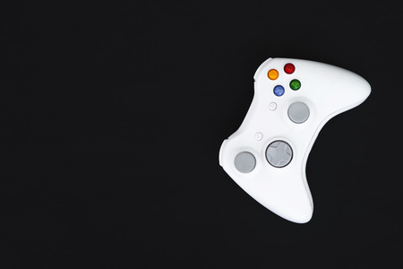White joystick on black background. The gamepad for the console is isolated on a dark background....