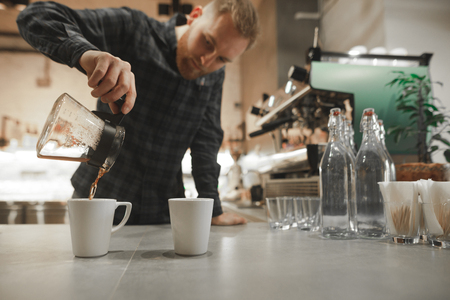 Professional barista spills fresh brewed pour-over made of the best Arabica roasted beans in the coffee shop. Perfect coffee background with copy space.の写真素材