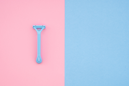 One blue razor isolated on a pink background, blue background for Copyspace. Flat layの写真素材