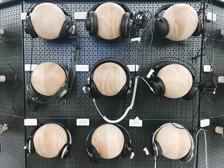 Department of headphones in the technology store. Buy and choose headphones in the electronics store. Headphone wall for listening to the store.の写真素材