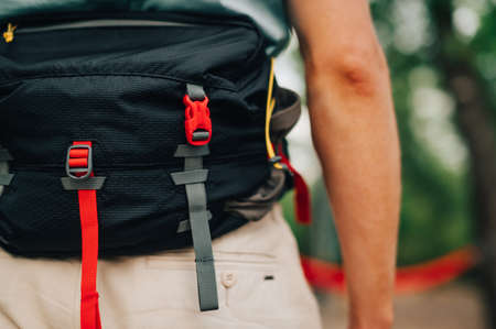 Close-up, cropped photo. Waist bag for travel on the belt of a man on a background of blurred background in the woodsの写真素材