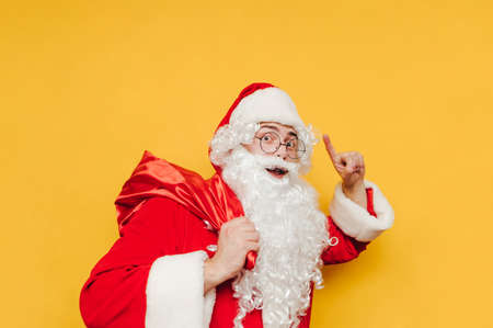 Cheerful Santa Claus has an idea for Christmas presents, bringing the goods in his red sack....