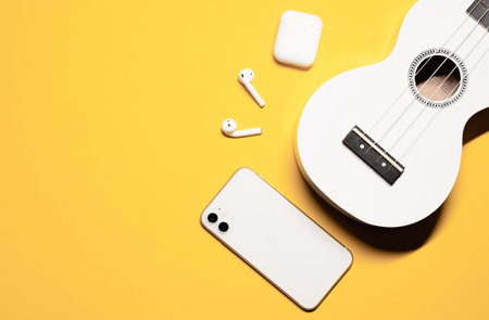 Beautiful flat lay photo with a white small hawaiian ukulele soprano guitar with 4 nylon strings,...