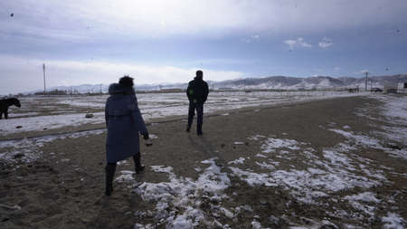 A man and a woman are walking in the snow.の写真素材