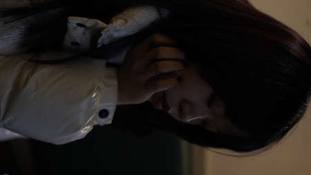 Close up of a young woman suffering from depression and anxiety sitting alone in the darkの写真素材