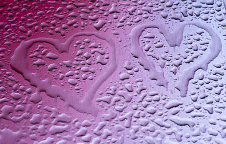 Water drops form hearts on a metal surfaceの写真素材