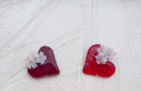 Two red glass hearts covered by iceの写真素材