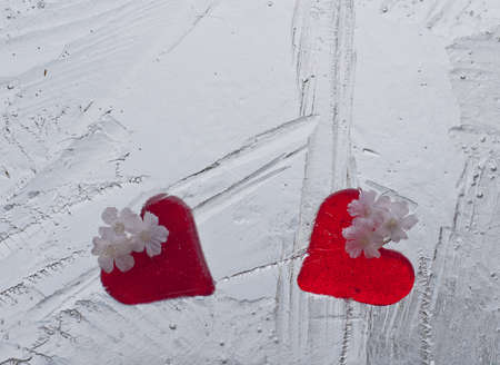 Two red glass hearts covered by iceの写真素材