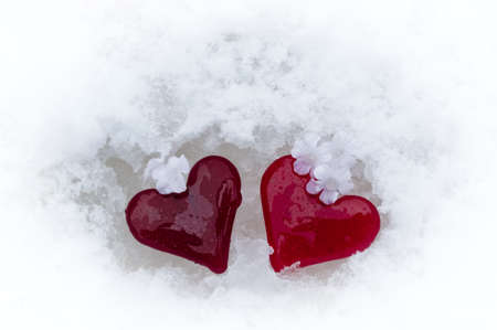 Two red glass hearts in the melting snow