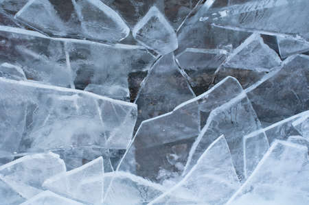 Broken ice on the edge of a lake at winterの写真素材