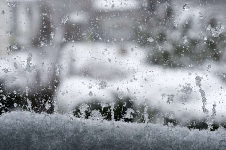 Watching through at a snow-covered windowの写真素材