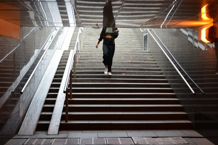 A girl is walking down a staircase.の写真素材