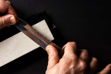 Sharpening a knife in your hand using the grindstoneの写真素材
