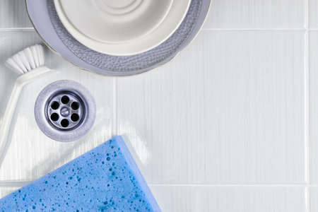 The dishes in the sink with a brush and spongeの写真素材