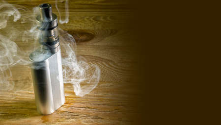 Electronic cigarette standing on the table shrouded in steam