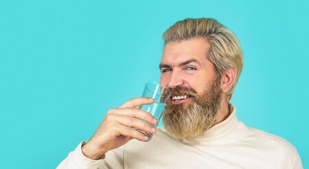Male drinking from a glass of water. Health care concept photo, lifestyle, close up. Happy beard man...