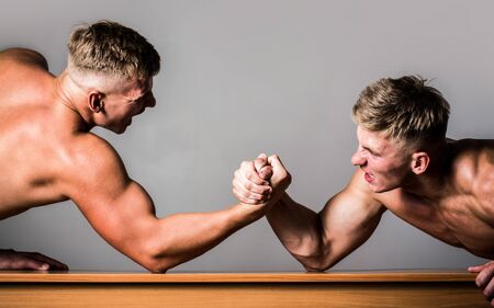 Men measuring forces, arms. Hand wrestling, compete. Hands or arms of man. Muscular hand. Arm wrestling. Two men arm wrestling. Rivalry, closeup of male arm wrestling. Two handsの写真素材