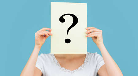 Girl holding paper question mark. Unknown woman holding question mark. Female incognita. Girl...