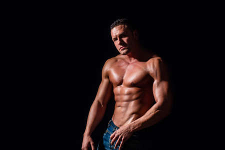 Sporty man. Sport workout bodybuilding concept. Sexy closeup topless male model. Sexy naked torso. Sport workout bodybuilding concep. Muscular torso and chest. Isolated on black backgroundの写真素材