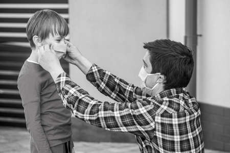 Dad with a son in a medical mask. Father puts a medical mask on her son. Coronavirus, illness,...