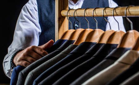 Tailor, tailoring. Stylish mens suit. Male suits hanging in a row. Men clothing, boutiques. Man...