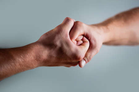 Two hands, isolated arm, helping hand of a friend. Handshake, arms. Friendly handshake, friends greeting. Rescue, helping hand. Male hand united in handshake. Man help hands, guardianship, protectionの写真素材