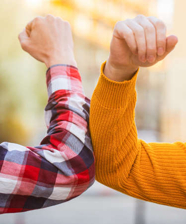 Two people bump elbows to avoid coronavirus outdoors. Coronavirus epidemic. Closeup elbow bump. Elbows bump. Health care concept. Social distancingの写真素材