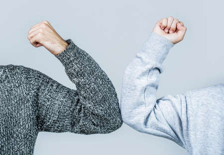 Closeup elbow bump. Two people bump elbows to avoid coronavirus. Coronavirus epidemic. Elbows bump. Health care concept. Social distancingの写真素材