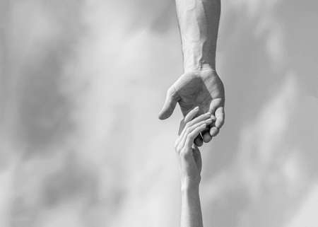 Hands of man and woman on blue sky background. Lending a helping hand. Hands of man and woman...