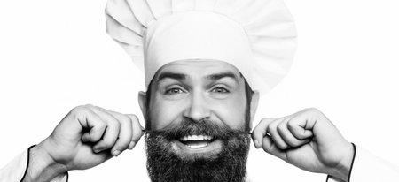 Closeup face of a cook in a hat. Funny chef with beard cook. Portrait of a happy chef cook. Black and whiteの写真素材