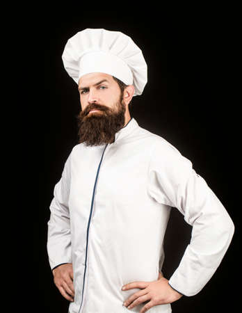 Portrait of a serious chef cook. Bearded chef, cooks or baker. Bearded male chefs isolated on black. Cook hat. Confident bearded male chef in white uniform. Serious cook in white uniform, chef hatの写真素材