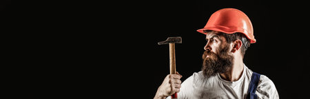 Handyman services. industry, technology, builder man, concept. Bearded man worker with beard, building helmet, hard hat. Hammer hammering. Builder in helmet, hammer, handymanの写真素材
