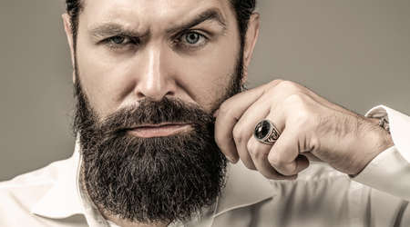 Bearded man close up. Beard is his style. Male with mustache growing. Portrait of bearded male in white shirt. Close up of handsome beard hipster elegant maleの写真素材
