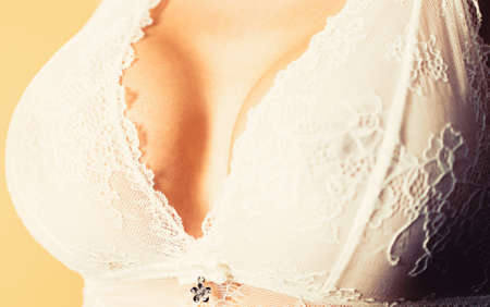 Close up of breast of girl presenting her bra. Sensual women, huge breasts, big boobs. Sexy sensual girl. Closeup of sexy female boob in white bra. Plastic surgery. Sexy boobの写真素材