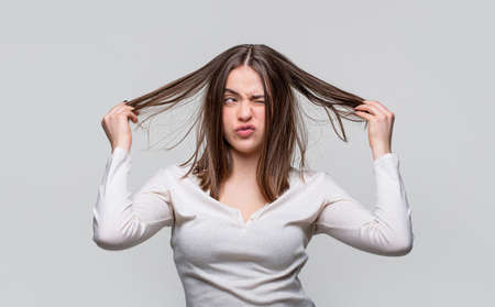 Frustrated woman having a bad hair. Woman having a bad hair, her hair is messy and tangled. Messy hair. Brunette woman with messed hairs. Girl having a bad hair. Bad hairs dayの写真素材