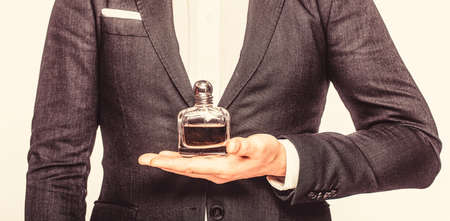 Perfume or cologne bottle and perfumery, cosmetics, scent cologne bottle, male holding cologne. Male holding up bottle perfume. Man in a suit holding a bottle of perfume isolated on white backgroundの写真素材